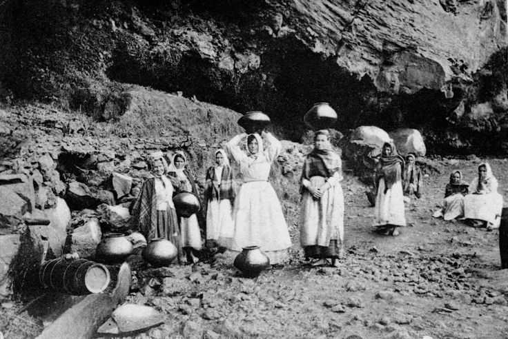 Mulheres com bernegales na cabeça, carregando água por volta de 1931
